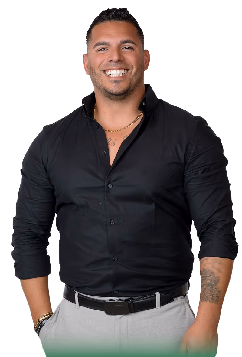Veteran man smiling and wearing a black button down shirt with a tattoo on his arm